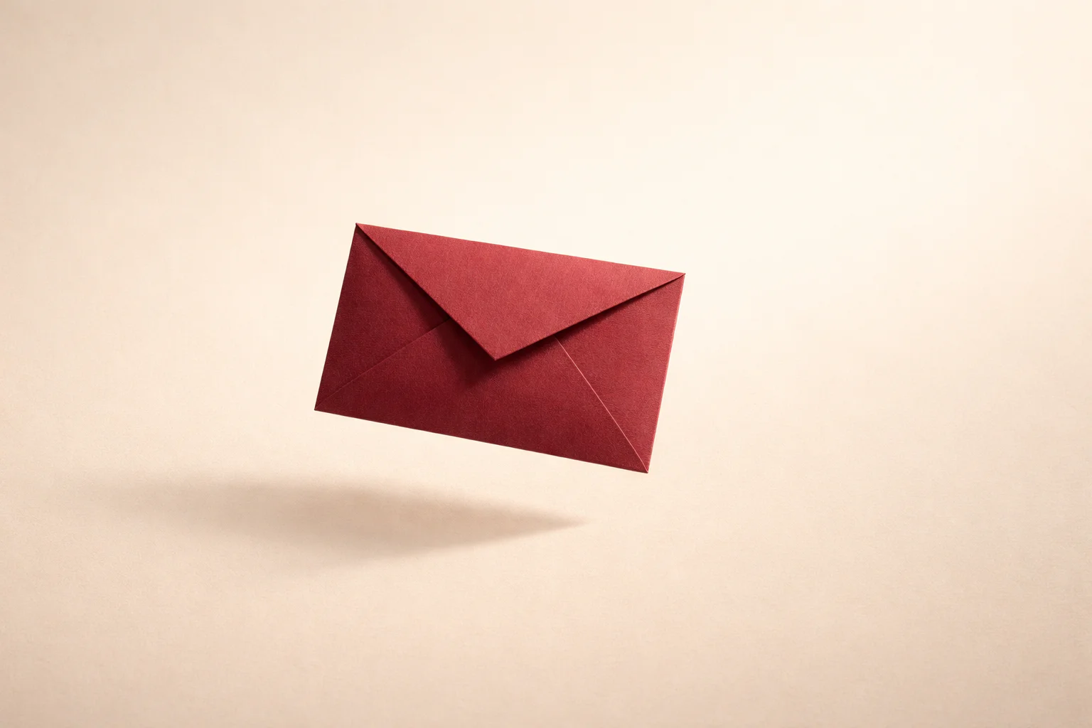 A folded deep red paper envelope on a cream background.