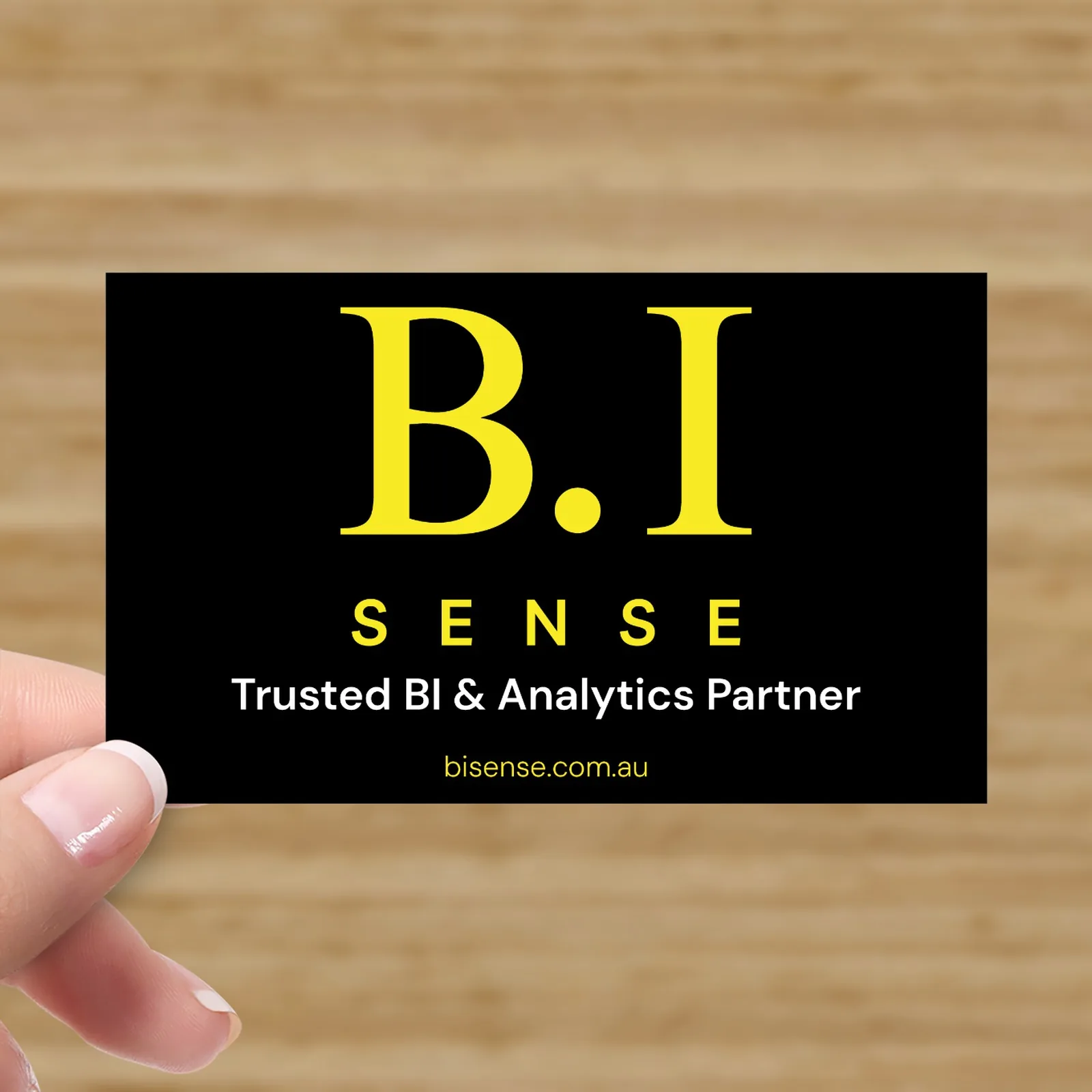 B.I Sense business card front design featuring black background, yellow logo typography and Trusted BI & Analytics Partner tagline.