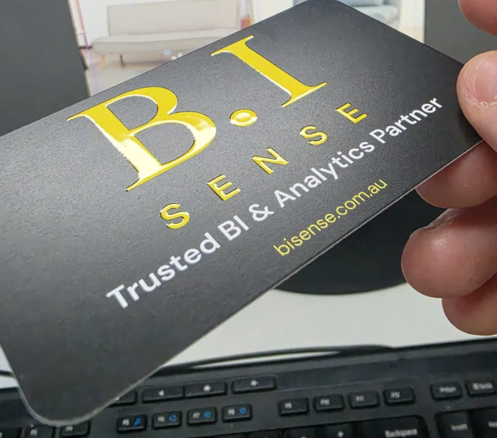 Close-up of the B.I Sense business card designed by Lovely Pixel: a raised 3D UV-printed logo on premium matte black stock, with the line Trusted BI and Analytics Partner.